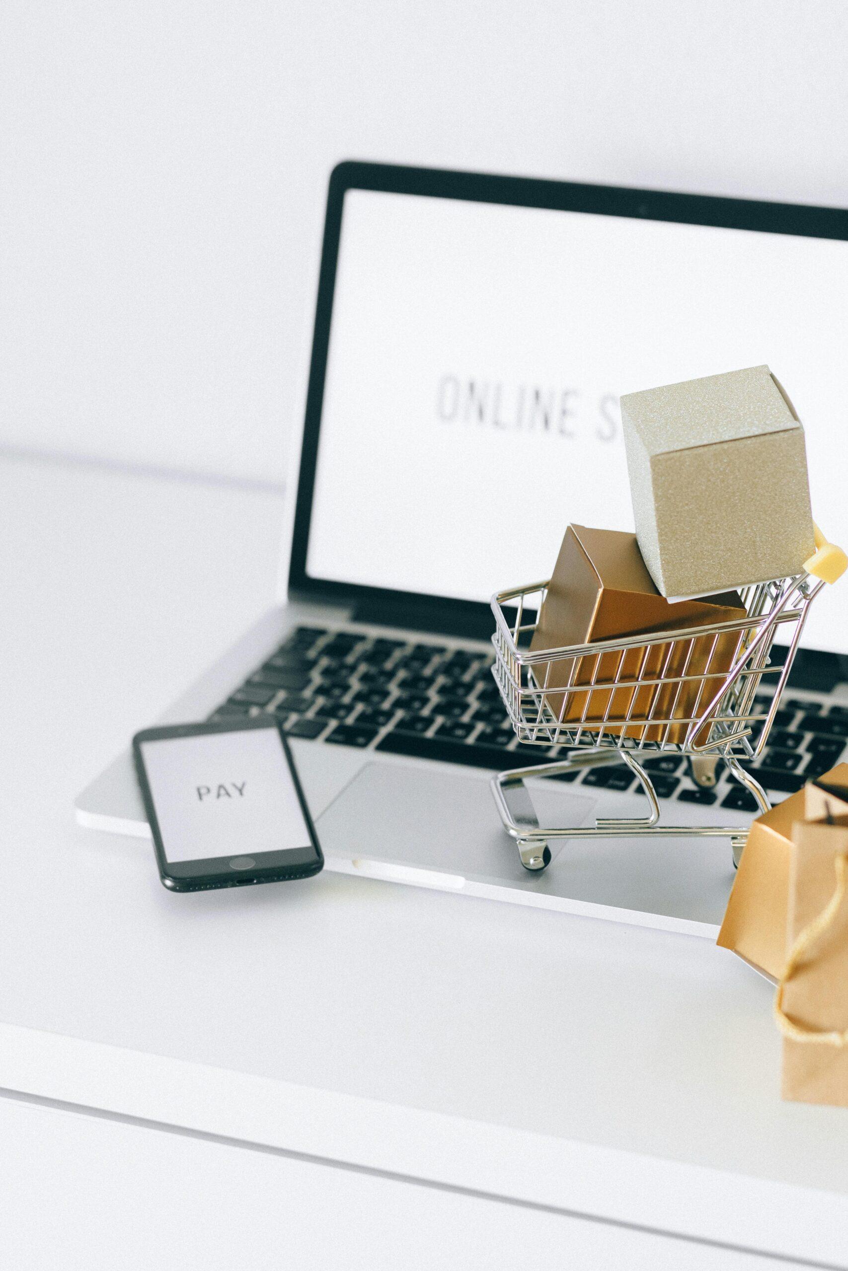 Mini shopping cart on laptop symbolizing online shopping and e-commerce transactions.